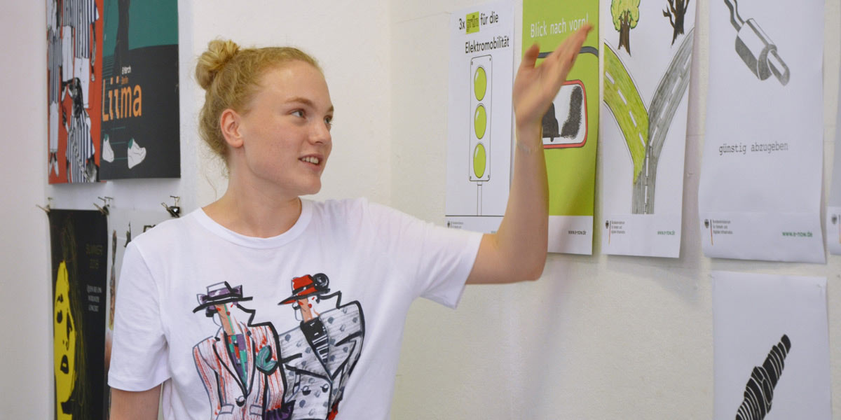 Sommerakademie - Kurs Illustration kennenlernen - Teilnehmerin präsentiert ihr Plakat